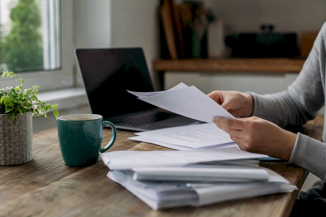 Hands sorting bank statements on desk
