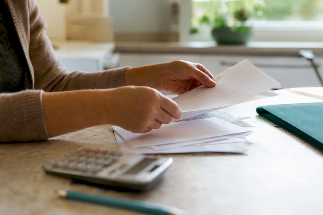 Hands sorting tax and pay stub documents